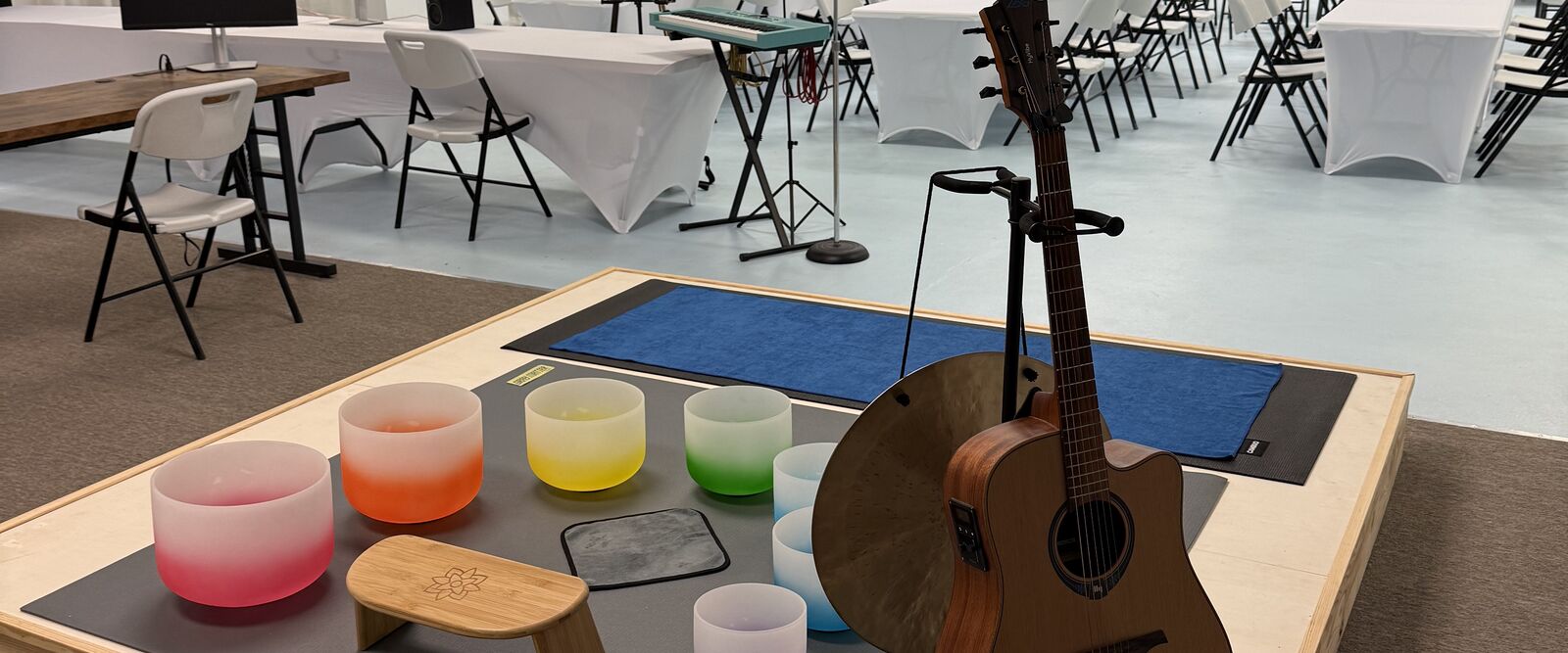 Stage with crystal singing bowls and an acoustic guitar
